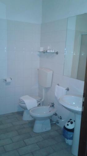ein weißes Bad mit einem WC und einem Waschbecken in der Unterkunft Agriturismo San Bruno in San Colombano al Lambro