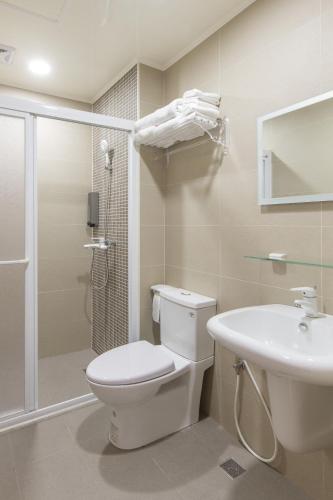 a bathroom with a toilet and a sink and a shower at Sanwu Homestay in Magong
