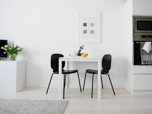 ヘルシンキにあるRoost Kristianの白いテーブル(黒い椅子3脚付)