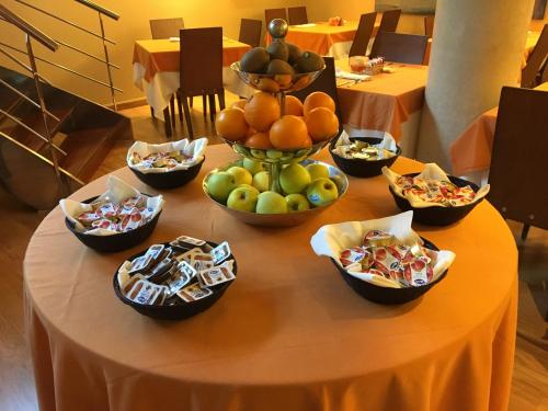 a table topped with bowls of fruit and snacks at Hotel Campoamor in Oviedo