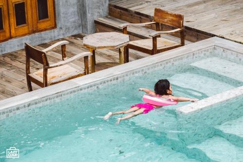 a young girl in a pool with a float at House Of Passion Amphawa in Amphawa