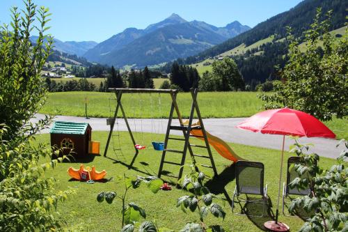 a playground with a swing and an umbrella at Moahof in Alpbach