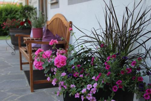 a bench with flowers and potted plants on a patio at Moahof in Alpbach