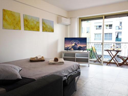 um quarto com uma cama e uma televisão de ecrã plano em Le Sunlight, quiet and cosy with terrace! em Nice