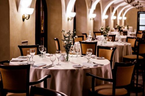 eine Reihe von Tischen in einem Restaurant mit weißen Tischdecken in der Unterkunft Turówka Hotel & Spa in Wieliczka