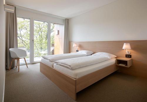 um quarto com uma cama grande e uma janela grande em APPADU Appartements em St. Gallen