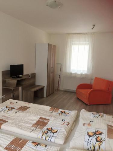 a living room with two beds and a red couch at Promenád apartmány in Veľký Meder