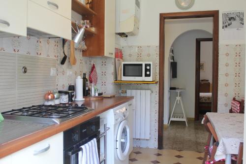 a kitchen with a stove and a washer and dryer at Appartamento Liberazione - 5 Terre Region in Moneglia