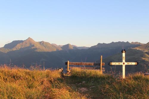 a cross on a hill with mountains in the background at Moahof in Alpbach