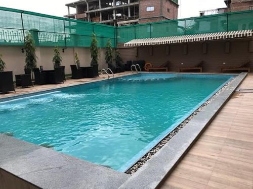 a large swimming pool with blue water in a building at Classic Grande,a Member of Radisson in Imphal