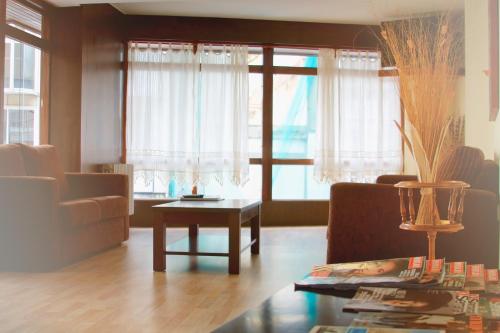 ein Wohnzimmer mit einem Sofa und einem Tisch in der Unterkunft Hotel Santa Catalina by Bossh Hotels in A Coruña