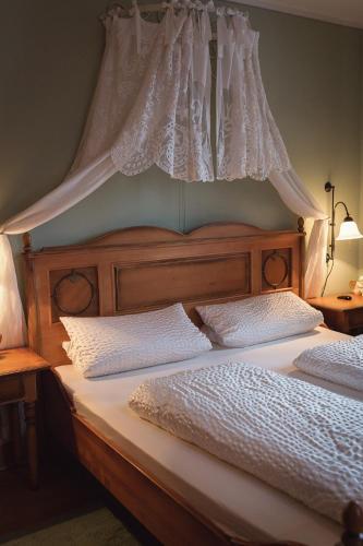 a bedroom with two beds with a canopy at Der Patrizierhof - Weingut Gasthof Hotel - Familie Grebner in Großlangheim
