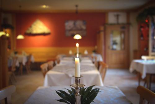 a candle on a table in a dining room at Der Patrizierhof - Weingut Gasthof Hotel - Familie Grebner in Großlangheim