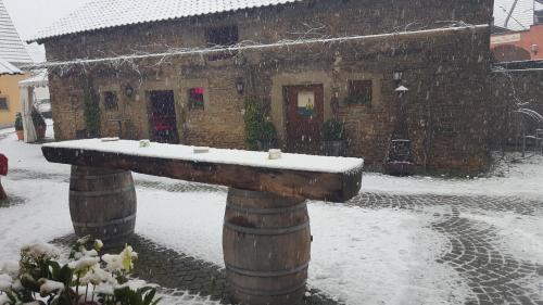 a snow covered stone bench in front of a building at Der Patrizierhof - Weingut Gasthof Hotel - Familie Grebner in Großlangheim