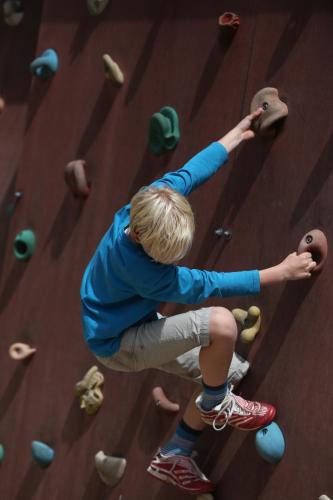 a young boy climbing on a rock wall at Jugendherberge Friedrichstadt in Friedrichstadt