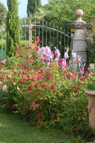 a garden of flowers in front of a fence at Le Mas des Clots in Upie