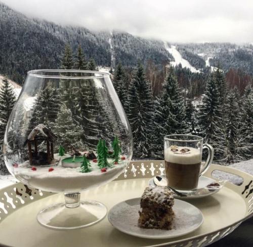 a table with a cup of coffee and a plate of food at Pensiunea Orizont in Poiana Brasov