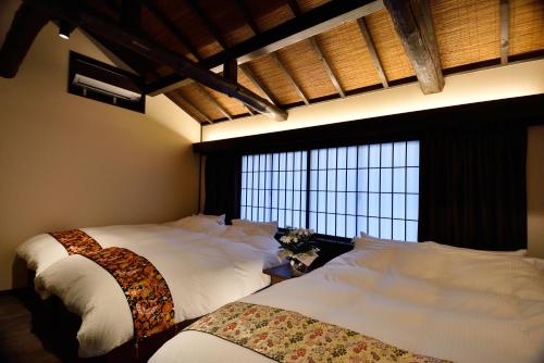 1 dormitorio con 2 camas y ventana grande en Miun Kinkaku-ji, en Kioto