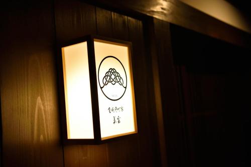 a light on a wall with a sign on it at Miun Kinkaku-ji in Kyoto