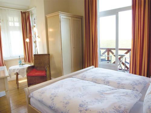 a bedroom with a bed and a view of a balcony at Hotel Villa Caldera in Cuxhaven