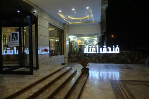 un vestíbulo de un edificio por la noche con luces en Aghnar Hotel, en Nayaf