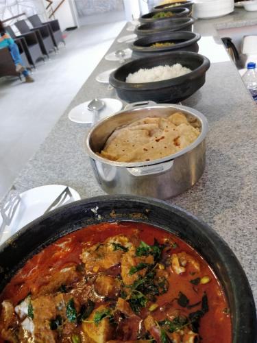 a row of bowls of food on a counter at The Birchwood Retreat, Madikeri in Madikeri