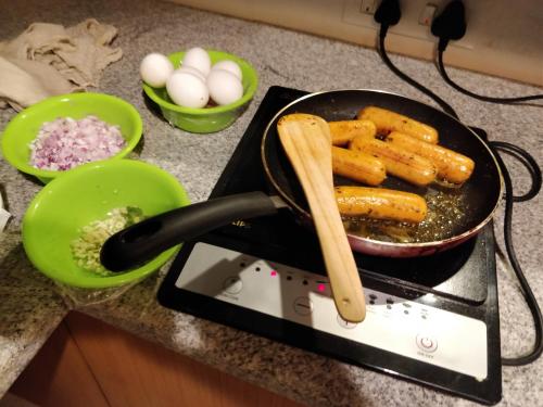 a pan of food on a stove with eggs at The Birchwood Retreat, Madikeri in Madikeri