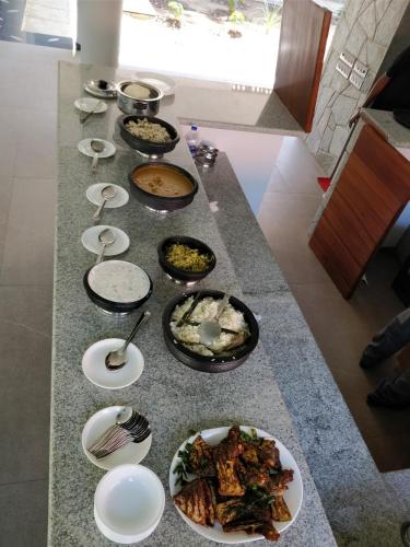 a table with many plates of food on it at The Birchwood Retreat, Madikeri in Madikeri
