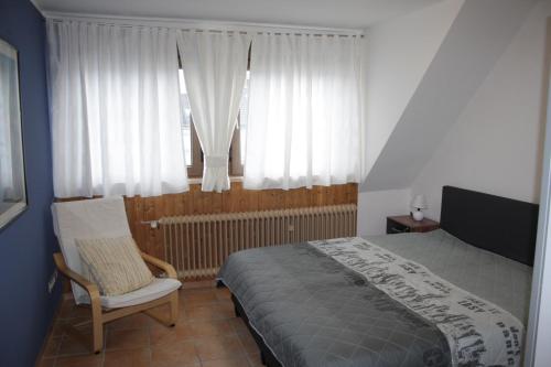 um quarto com uma cama, uma cadeira e uma janela em Ana-Marie em Bad Neuenahr-Ahrweiler