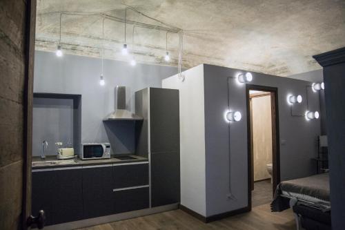 a kitchen with a sink and a microwave at La Canonica - charming self-catering apartments in Nizza Monferrato in Nizza Monferrato