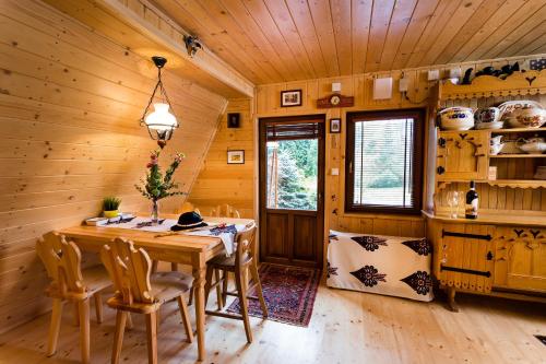 Un comedor de madera con mesa y sillas. en Góralski domek z kominkiem, wygodny, ciepły, zwierzaki mile widziane, ogrodzony, en Łopuszna