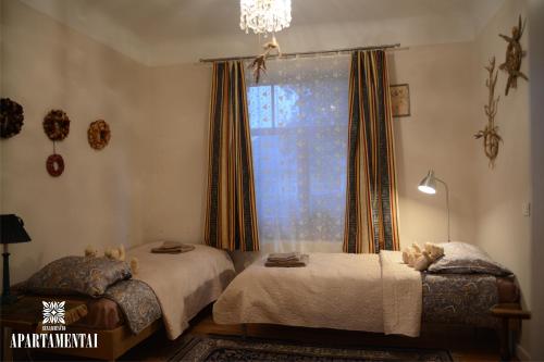 a bedroom with two beds and a window at Senamiesčio APARTAMENTAI in Panevėžys