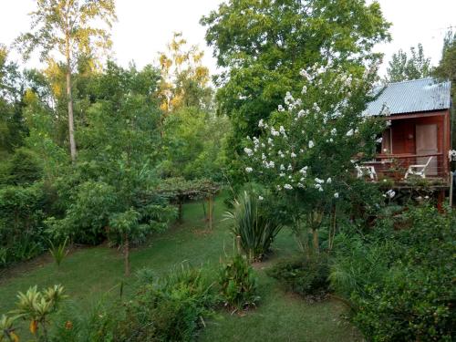 un jardín con flores blancas frente a una casa en Cabañas ICh en Tigre