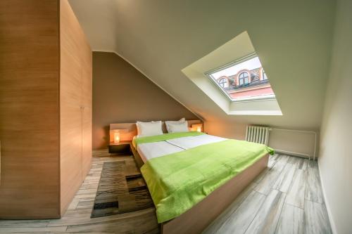 a attic bedroom with a bed with a skylight at Garni Citi Hotel Veliki in Novi Sad