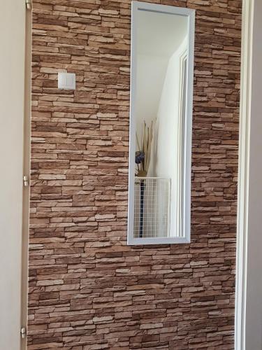 a mirror on a brick wall in a room at Mimi Apartment in Nyíregyháza