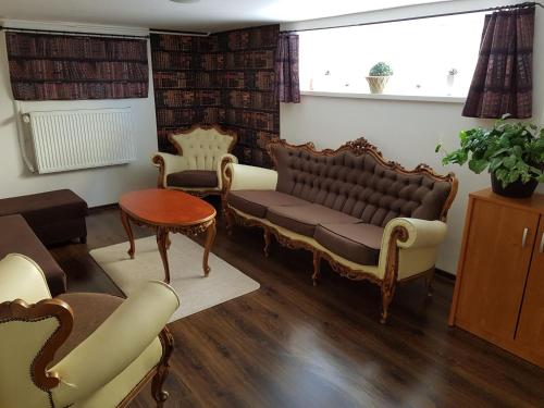 una sala de estar con un sofá y sillas en Mimi Apartment, en Nyíregyháza
