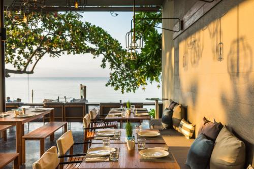 a restaurant with tables and chairs and a view of the ocean at Casa De Mar - Koh Samui in Chaweng
