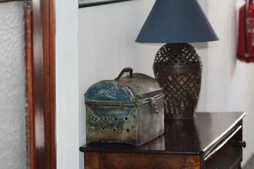 a table with a lamp and a container on it at Pinheiro de Monsaraz- Casa De Santa Maria T3 com piscina in Reguengos de Monsaraz