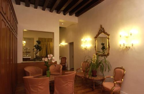 a room with a table and chairs and a mirror at Hotel Locanda Canal in Venice