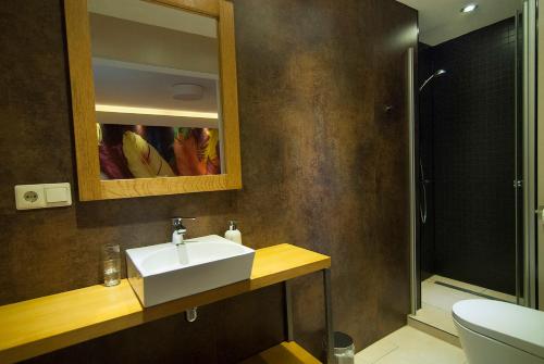 uma casa de banho com um lavatório branco e um chuveiro em B&B In de zevende hemel em Reijmerstok