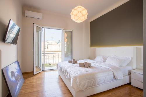 1 dormitorio con cama grande y ventana grande en Pagrati 2bdr Flat, en Atenas