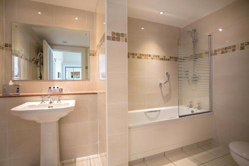 ein Bad mit einem Waschbecken, einer Dusche und einem WC in der Unterkunft Macdonald Linden Hall Hotel, Golf & Spa in Longhorsley
