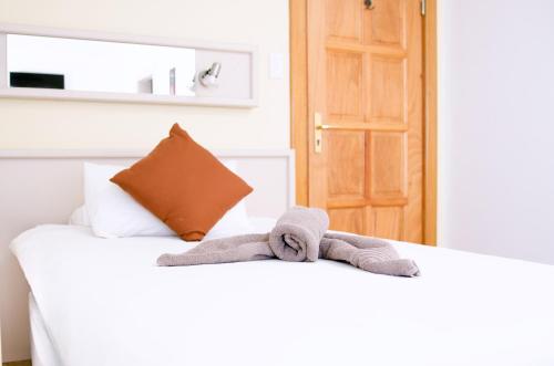 a pair of towels sitting on top of a bed at Hotel Deutsches Haus Swakopmund in Swakopmund
