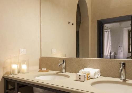 a bathroom with two sinks and a large mirror at Castello di Gabiano in Gabiano