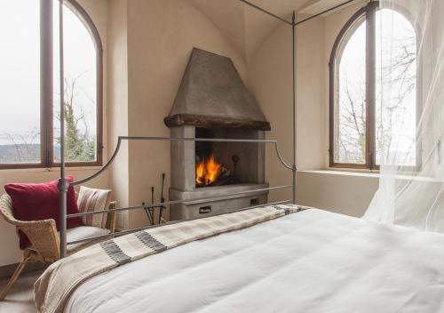 a bedroom with a bed and a fireplace at Castello di Gabiano in Gabiano