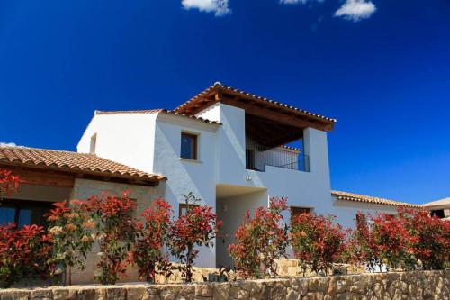 a white house with red flowers in front of it at Casa Carla in Budoni