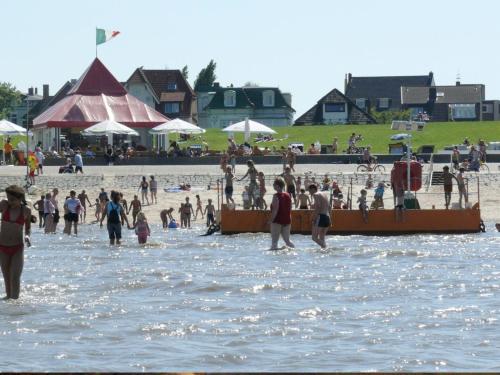a group of people standing in the water at a beach at Hotel Villa Caldera in Cuxhaven
