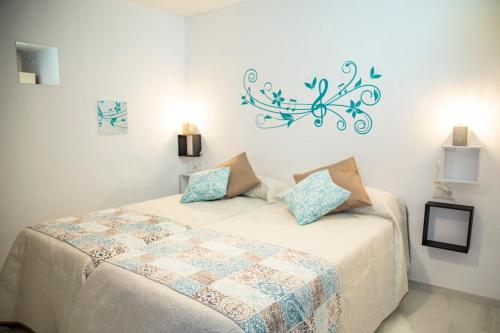 a bedroom with a bed with a blue decoration on the wall at La Casa Del Recreo in Cómpeta