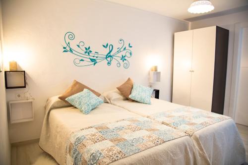 a bedroom with a bed with a chandelier on the wall at La Casa Del Recreo in Cómpeta
