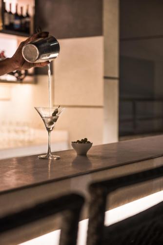 a person is pouring a drink into a martini glass at Hyatt Regency Lucknow Gomti Nagar in Lucknow